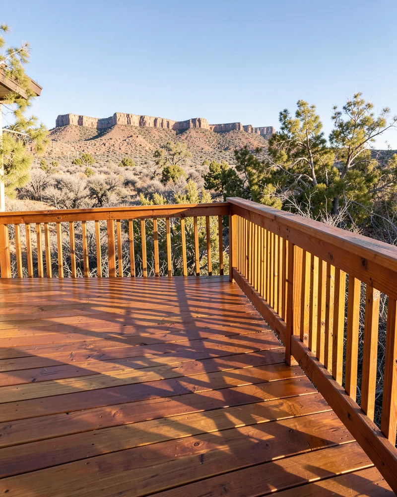 Freshly stained wooden deck with railing overlooking the Book Cliffs in Grand Junction, Colorado